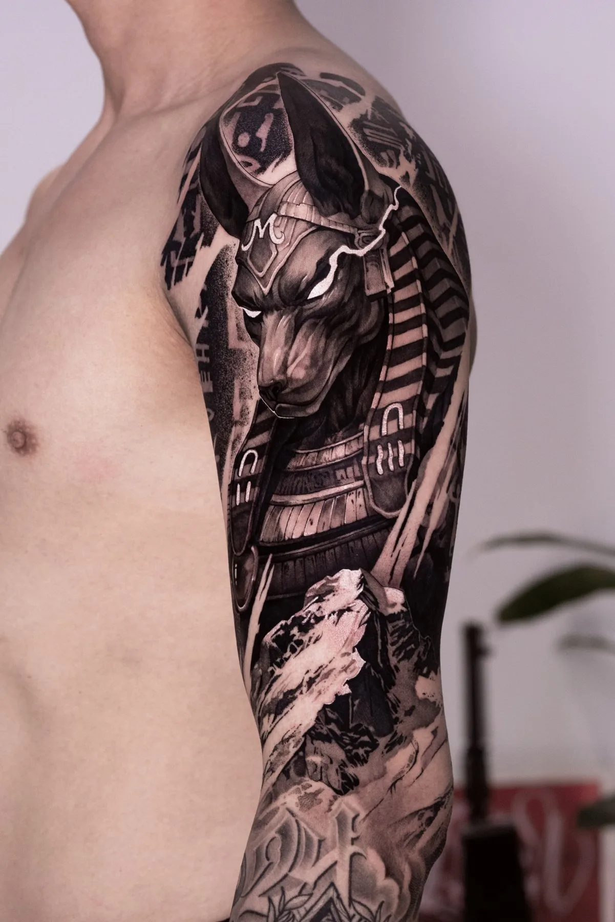 Anubis tattoo on the upper arm by Moussa in Shanghai